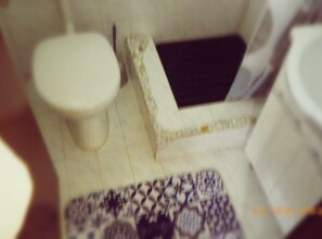 A close-up of a bathroom with a toilet, a sink, and a mirror.