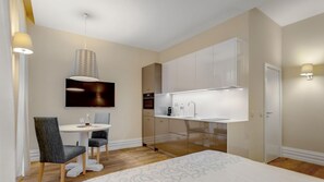 A modern kitchen with white cabinets, a built-in oven, and a countertop sink. - Oporto Wine Cellars (Vila Nova de Gaia)