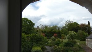 Een tuin met verschillende planten en een stenen muur.