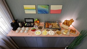 Monipuolinen aamiaisbuffet, jossa on tarjolla erilaisia ruokia sekä kahvipiste.