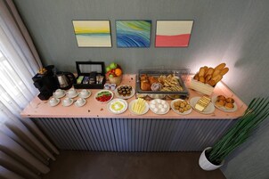 Un bufé de desayuno con diversas opciones de comida y una estación de café.
