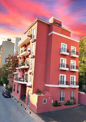 A red multi-story hotel with balconies, a sign reading "Comfort", and a clear sky. - COMFY APART HOTEL (Beirut)