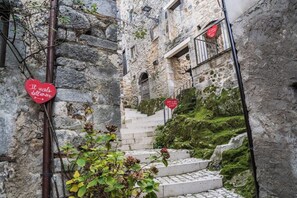 Una escalera de piedra que sube hacia un edificio con un letrero con forma de corazón.
