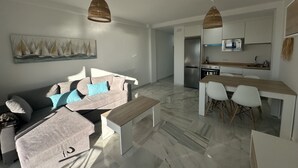 A modern living room with a sofa, a coffee table, and a dining area with chairs and a wooden table. There is a kitchen with a refrigerator, microwave, and sink. - Sunstay Relax 69 Rio Marina Nerja (Nerja)