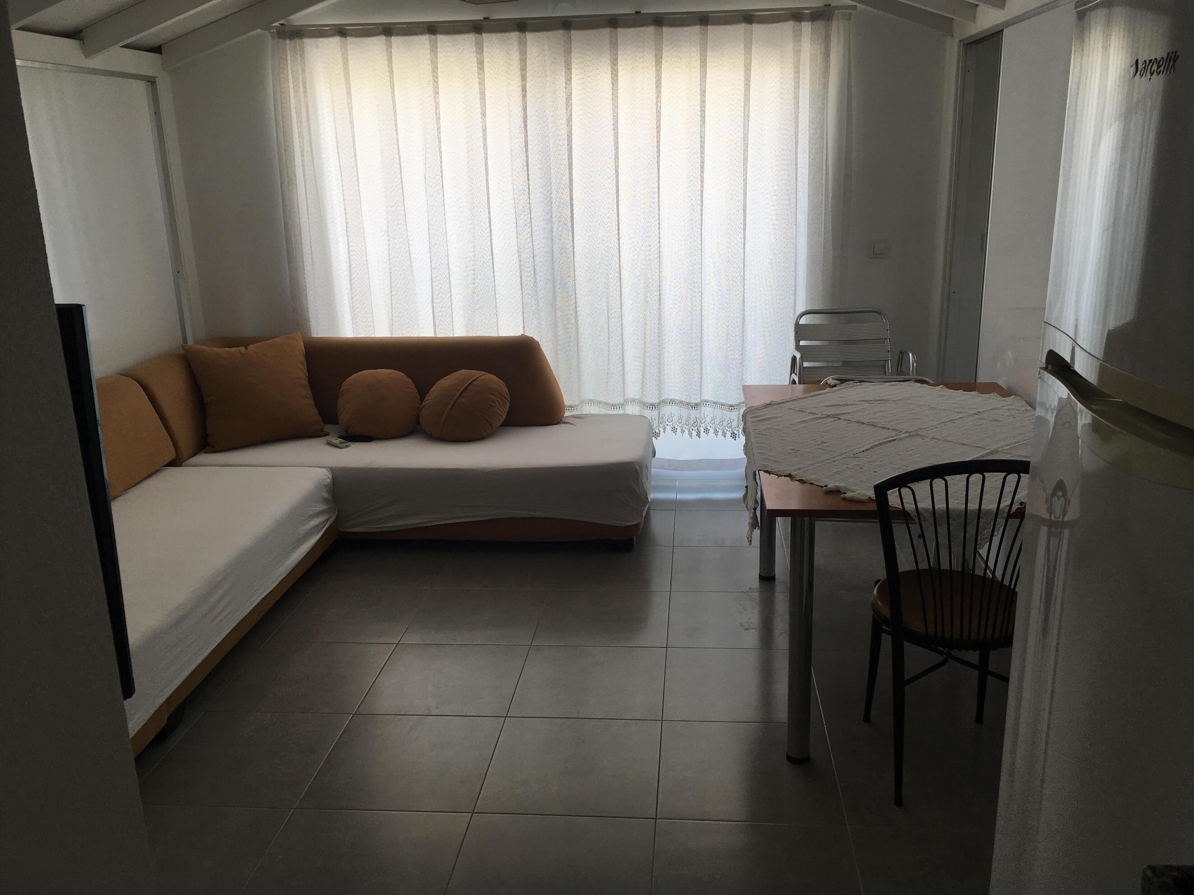 Una camera moderna e funzionale con divano letto, tavolo e una sedia.