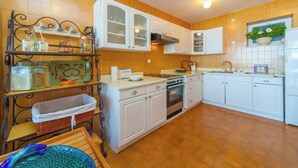 Una cocina con armarios blancos, una estufa y un lavamanos.