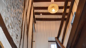 A wooden staircase with a handrail, a textured wall, and a hanging light fixture. - House Jaulice - 8 min Pont l'Evêque - 10 people (Le Torquesne)