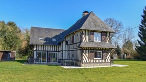 A traditional half-timbered house with a sloped roof, a covered porch, and a well-maintained lawn. - House Jaulice - 8 min Pont l'Evêque - 10 people (Le Torquesne)