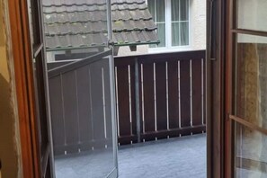 Enjoy the view from this traditional home's balcony, featuring a glass door and metal railing.