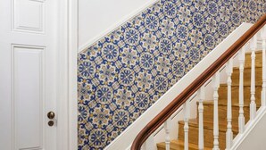 A staircase with white balusters and a wooden handrail, leading to a door with a brass doorknob. - Passeio de São Lázaro nº 5 (Porto)