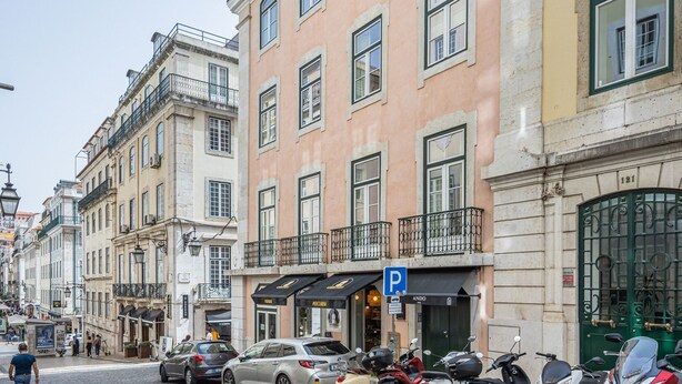 A street view with a building featuring a black awning with a 'P' sign indicating a parking area. - Ando Living - São Nicolau Townhouse (Lisbon)