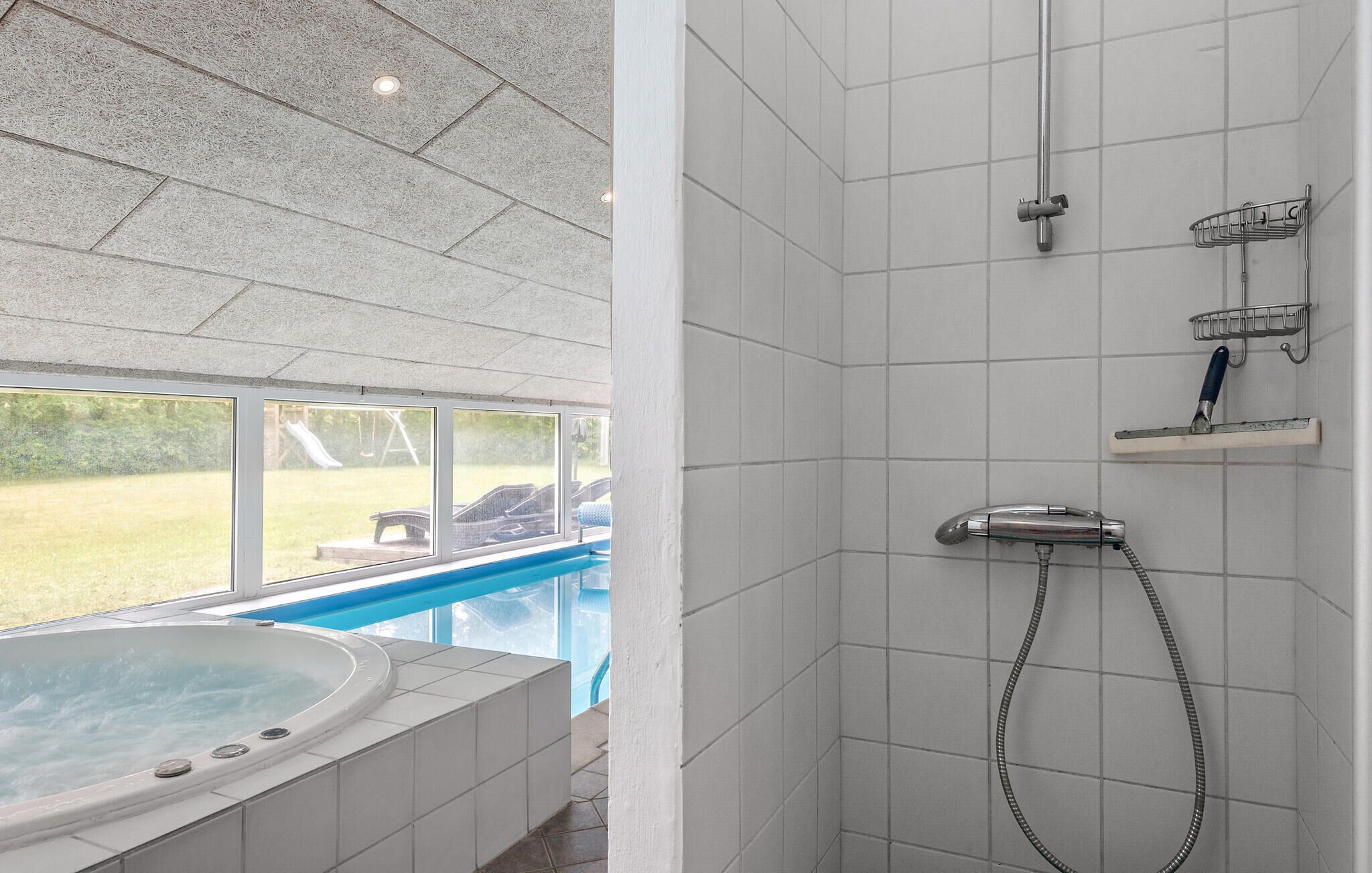 Ein Badezimmer mit Dusche, Badewanne und Fenster mit Blick auf einen Pool.