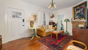 A living room with a sofa, a coffee table, a lamp, a rug, and a painting on the wall.