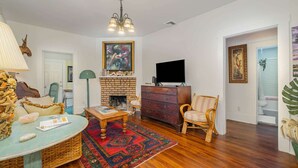 A living room with a fireplace, a television, and a large rug.