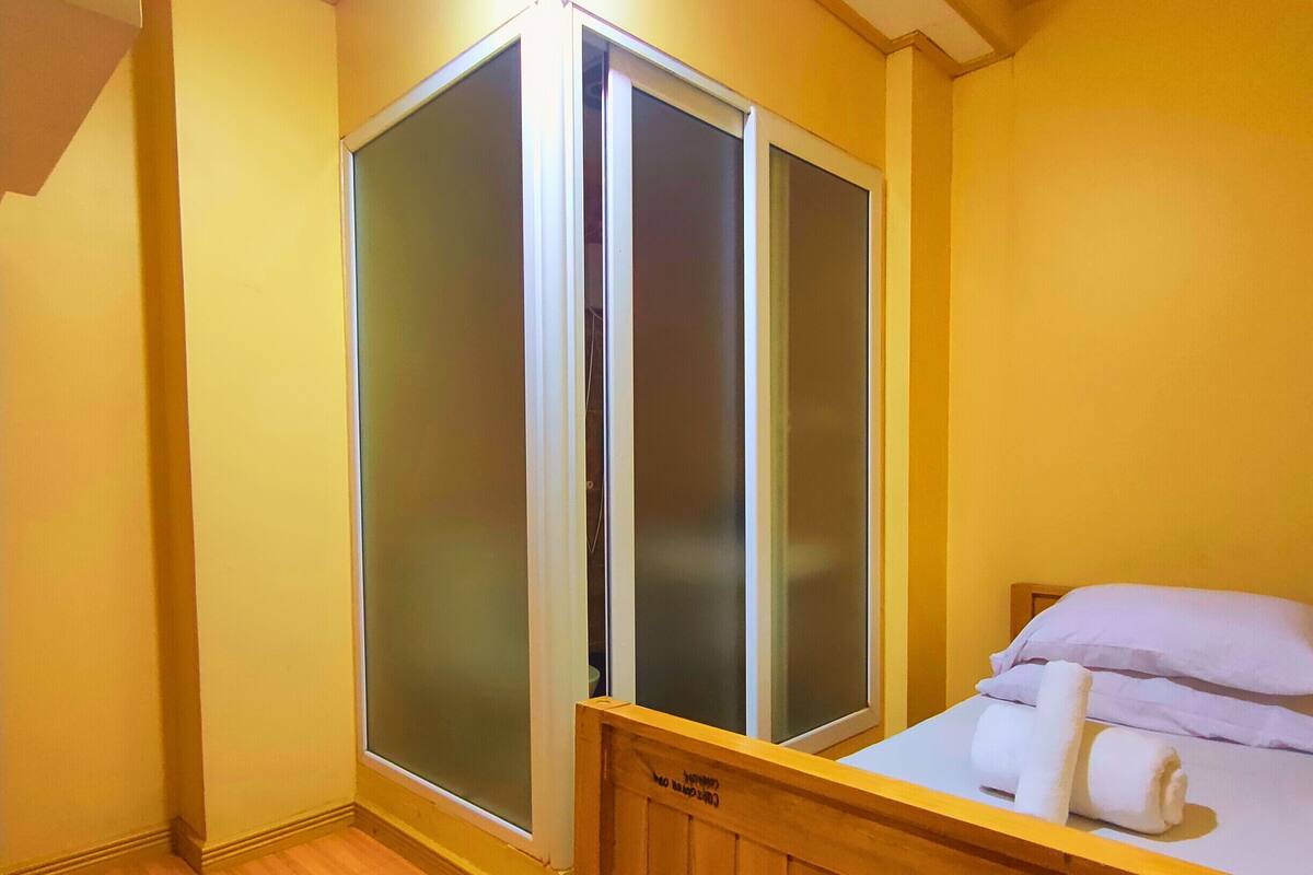 A room with a wooden bed, a sliding glass door, and a wooden floor.