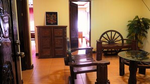 A wooden dining table with chairs, a wooden bench, a wooden cabinet, and a large wooden wheel chair.