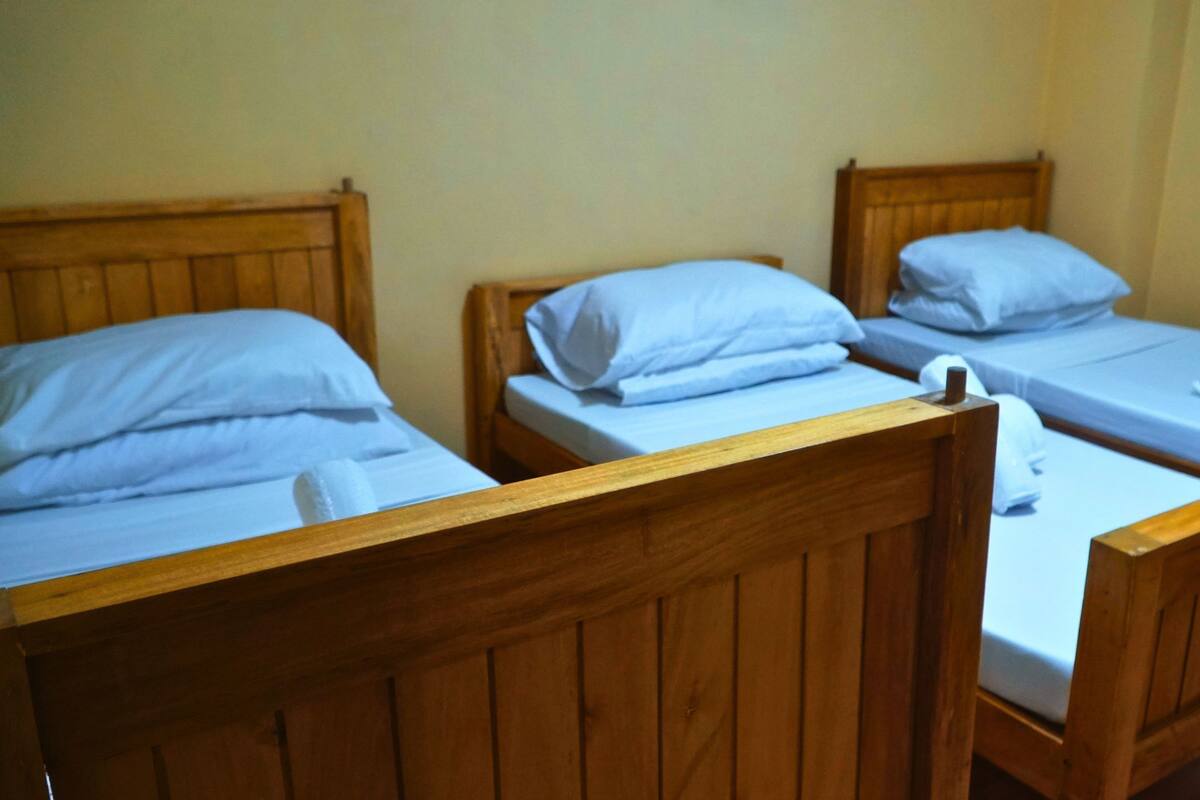 Three wooden bunk beds with white bedding.