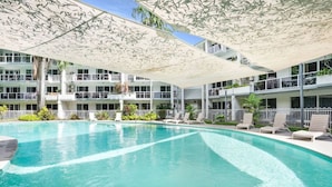 Ein modernes Hotel mit großem Innenpool, mehreren Balkonen und Außenbereichen zum Sitzen.