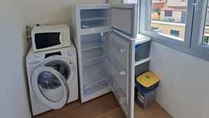 A laundry room with a washing machine, a dryer, and a refrigerator. - Bubi's Apartment, Intero Appartamento di 65mq (Livorno)