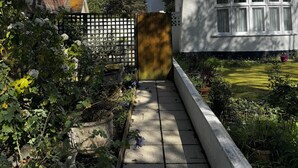 Un vialetto conduce a una casa bianca con facciata in mattoni e tetto rosso.