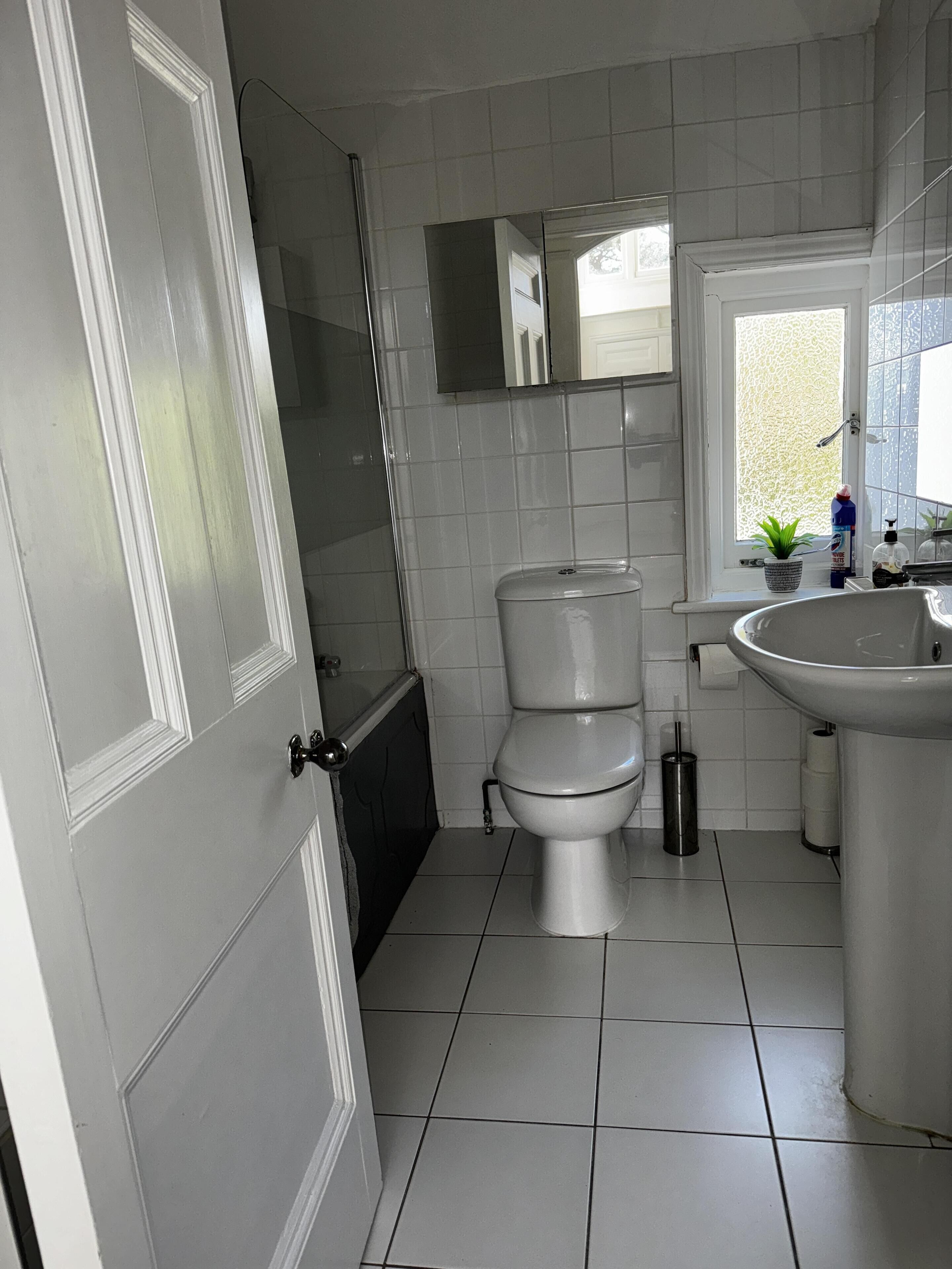 A bathroom with a toilet, sink, and shower.