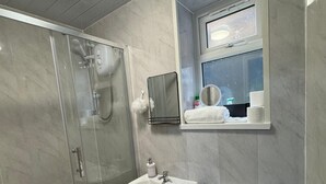 A bathroom with a glass-enclosed shower, a pedestal sink, and a toilet. - 1-bed Apart-nottingham-free Parking (Nottingham)