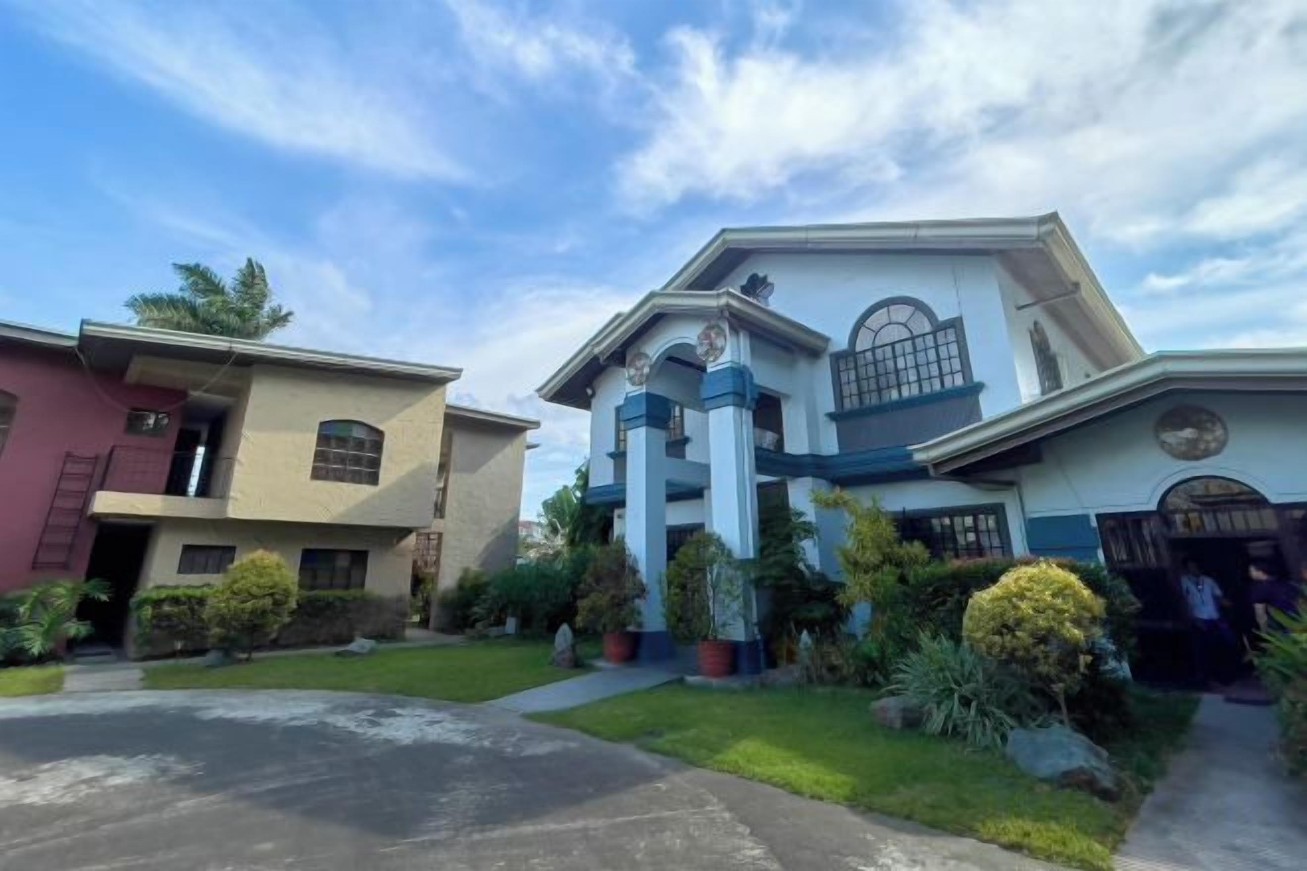 A two-story house with a front porch, a garage, and a driveway.