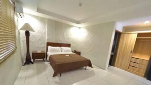 Un dormitorio con cama, mesitas de noche, lámpara y armario.