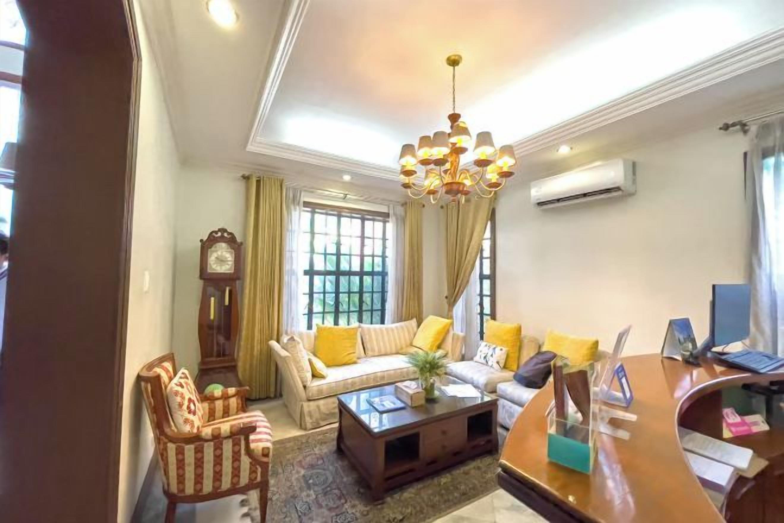 A living room with a sofa, armchairs, a coffee table, and a chandelier.