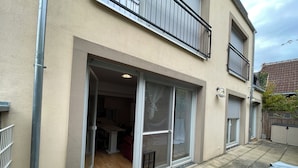 A residential building with a sliding glass door entrance, a balcony, and a small patio area. - MY-Skypalace Sinsheim (Sinsheim)