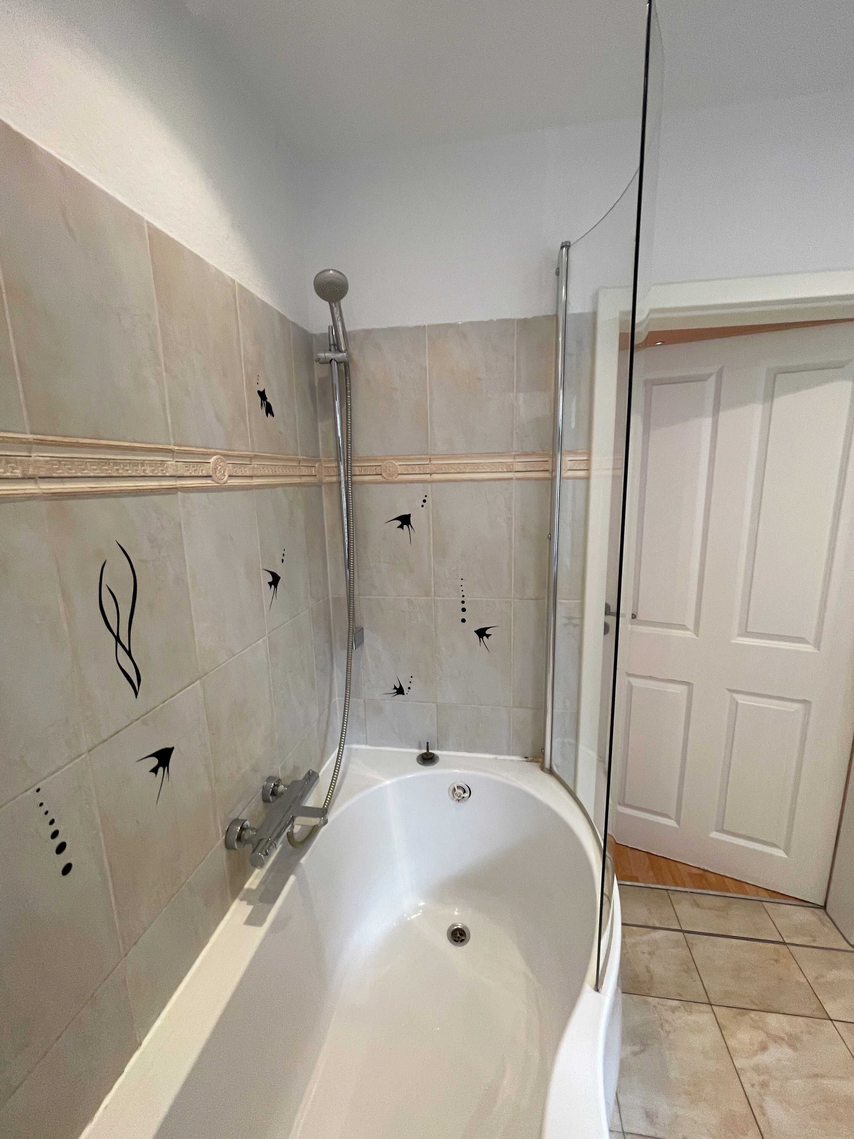Baño con bañera, ducha y una puerta.