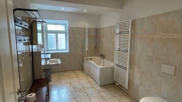 A modern bathroom with a bathtub, toilet, and sink.