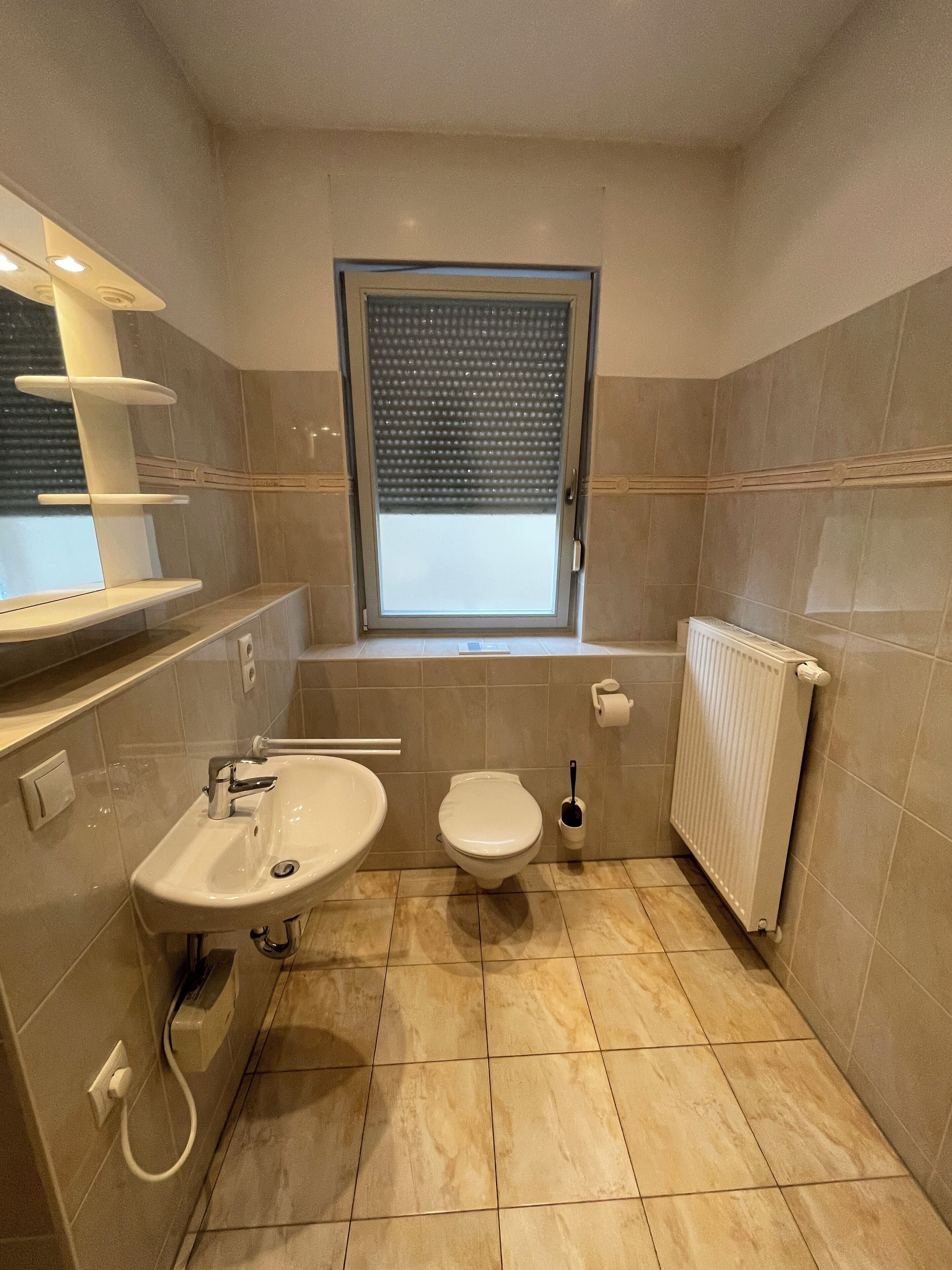 Une salle de bain moderne avec un lavabo, des toilettes et une fenêtre.