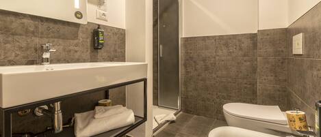 A modern bathroom with a large mirror, a sink, a toilet, and a shower area.