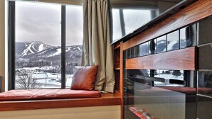 A room with a large window overlooking a snowy mountain landscape. - Mountain Views at Mt Green: 2 BR/2BA, Shuttle, Discounted Ski Rentals, Pool, Hot Tub and More! (Killington)