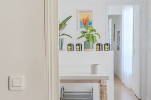 Enter a serene space with a framed poster, potted plant, and stylish storage.