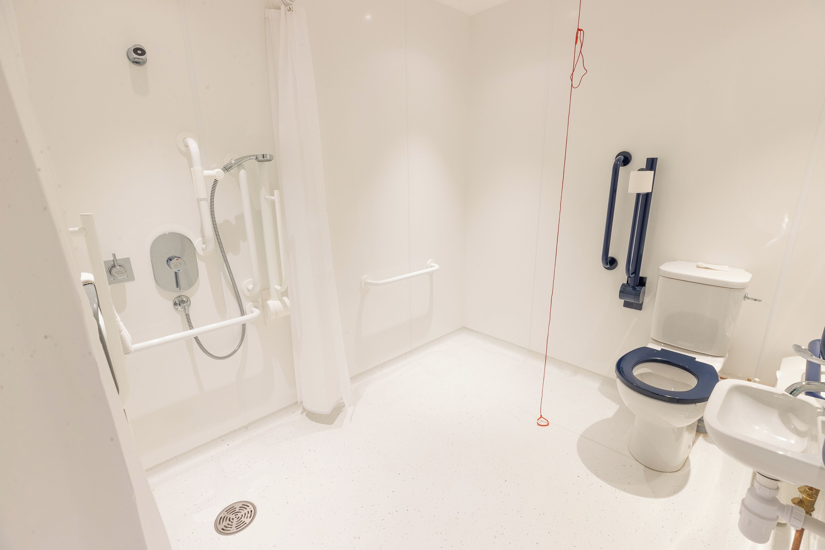 Un baño moderno con ducha, inodoro y lavamanos.
