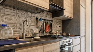 A modern kitchen with wooden cabinets, a stainless steel sink, and a built-in oven. - Via Coriolano 8 in Naples (Naples)