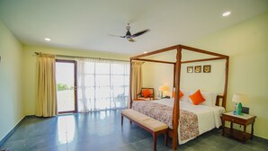 Una cama con dosel, un banco, una mesita de noche y una mesilla con lámpara.
