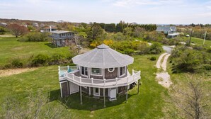 A large, multi-story house with a central tower and a wrap-around deck. - Block Island - 4 Bedroom Home on West Beach Road w/ Panoramic Ocean Views + AC! (New Shoreham)