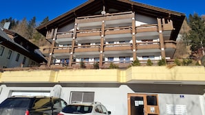 Ein mehrstöckiges Gebäude mit Balkonen, einer Garage und einem Schild mit der Nummer 7.