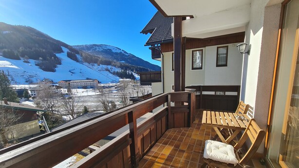 Ein Balkon mit Blick auf einen verschneiten Berg und ein Skigebiet.