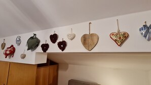 Una stanza con un'armadio in legno, un divano grigio e un tavolo con una lampada.