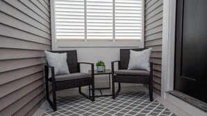 Un coin salon avec deux fauteuils, une petite table et une plante en pot.