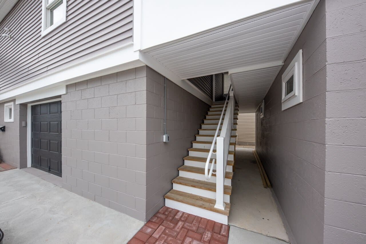 Un immeuble résidentiel avec un escalier menant à un garage.
