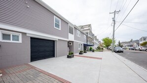 A residential street with houses, a sidewalk, and parked cars. - 3BR - Walk to Beach + Boardwalk | Near Downtown OC (Ocean City)
