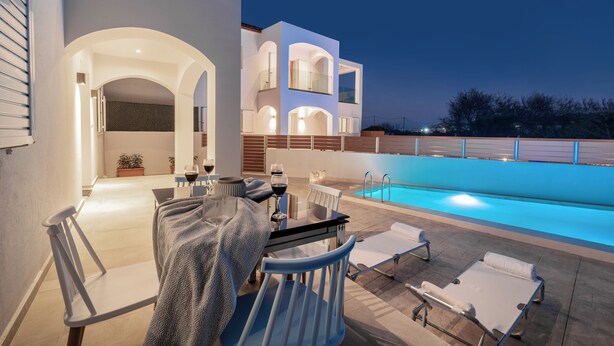 A modern outdoor pool area with a dining setup and lounge chairs.
