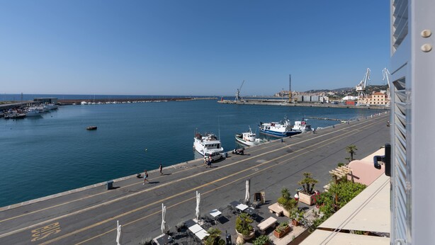 A coastal marina with boats docked, a wide promenade, and a clear sky. - Italianway - Vele D'Amare (Imperia)