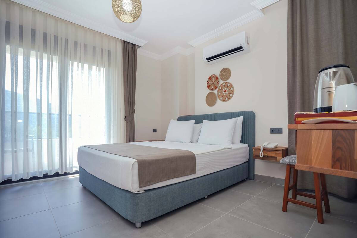 Une chambre d’hôtel équipée d’un lit, d’un bureau, d’une chaise et d’une machine à café.