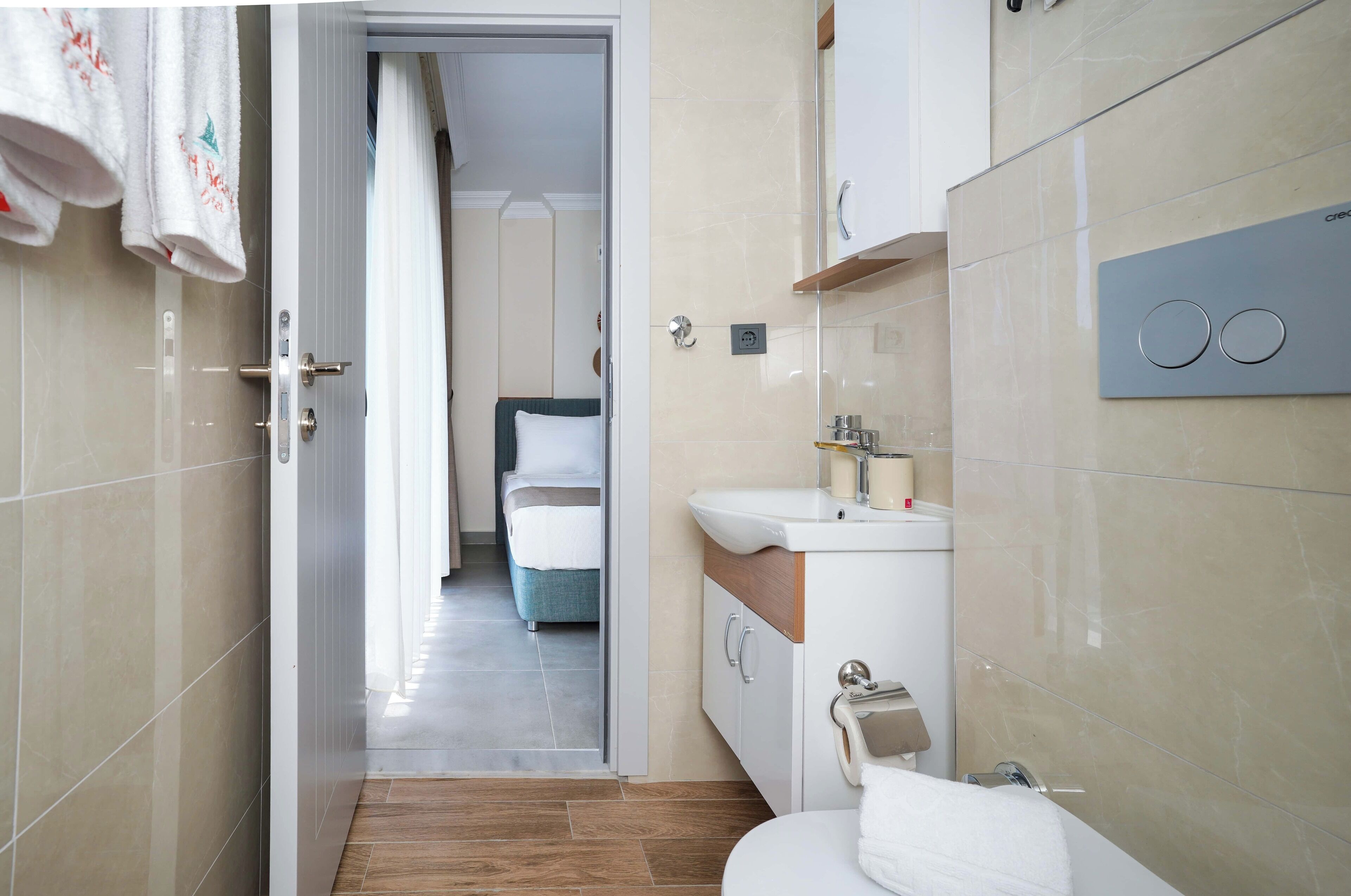 Un baño moderno con lavabo, espejo y perchero para toallas.